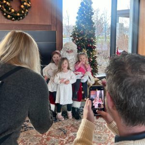 Parents takes photos of their children sitting with Santa at Ford House.