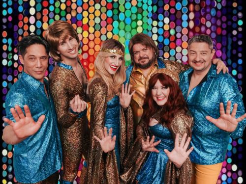 Six people dressed in blue sequins and spandex in the style of ABBA