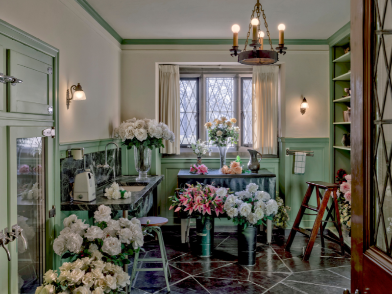 The Flower Room at Ford House, with green walls, marble countertops, flower arranging sinks, and fresh cut flowers displayed throughout.