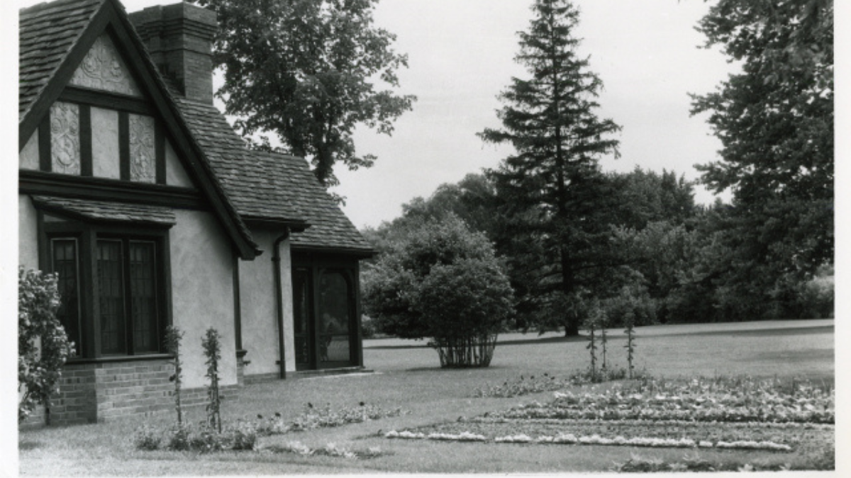 Historic black-and-white photo of the exterior of Josephine’s Playhouse, showcasing Tudor Revival architecture and formal garden beds.